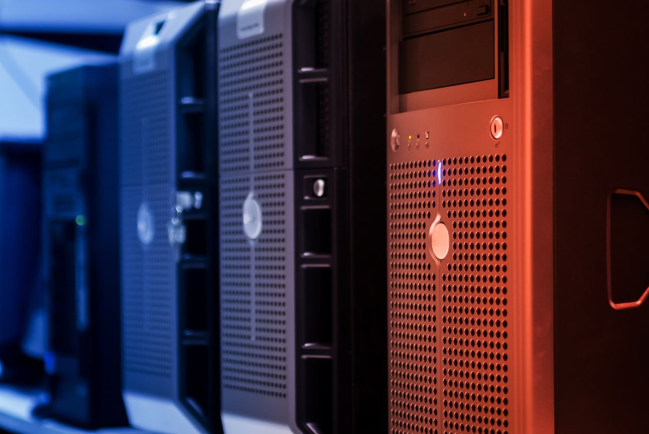 About Close-up of tower servers in a data center with blue and red lighting.